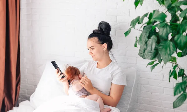 Familjen Ung Mamma Med Ett Nyfött Barn Sitter Snövit Säng — Stockfoto