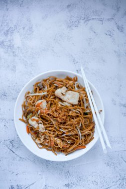 Çin usulü kızarmış erişte, karışık deniz mahsulü ve tavuk.