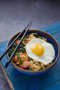 Endonezya usulü kızarmış pirinç, Nasi Goreng sosis ve sebzeli, güneşli bir tarafı var.