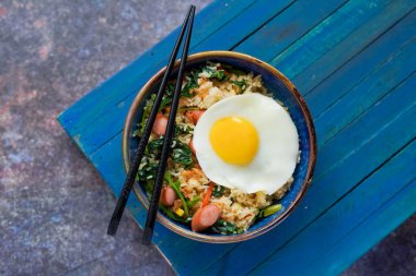 Endonezya usulü kızarmış pirinç, Nasi Goreng sosis ve sebzeli, güneşli bir tarafı var.