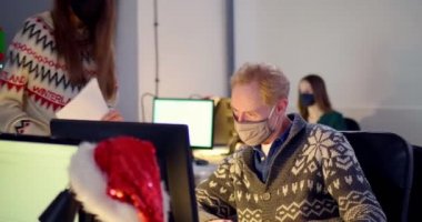 Maskeli insanlar ofiste masabaşında konuşuyor.