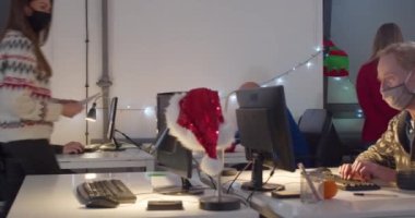 Geceleri ofiste çalışan maskeli insanlar.