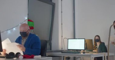 Geceleri ofiste çalışan maskeli bir adam.