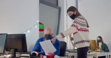 Geceleri ofiste çalışan maskeli insanlar.