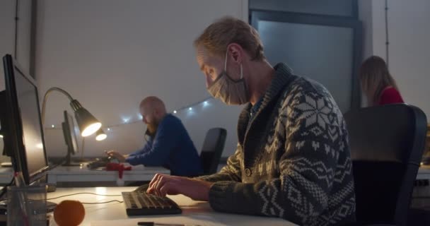 戴面具的男人晚上在电脑前工作 — 图库视频影像