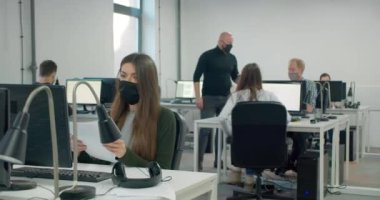 Erkek işçi ofisteki meslektaşları için dezenfektan kullanıyor. 