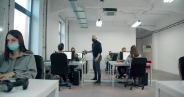 Erkek işçi ofisteki meslektaşları için dezenfektan kullanıyor. 
