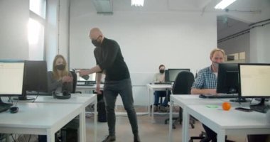 Erkek işçi ofisteki meslektaşları için dezenfektan kullanıyor. 