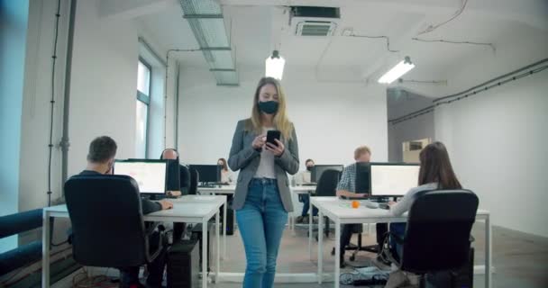 Empresária Usando Máscara Segurando Smartphone Enquanto Caminha Escritório — Vídeo de Stock