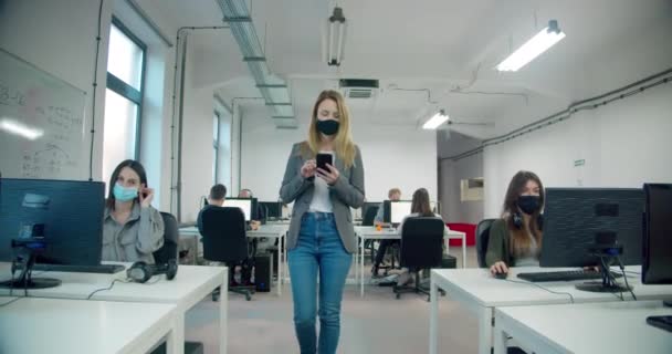 Empresária Usando Máscara Segurando Smartphone Enquanto Caminha Escritório — Vídeo de Stock