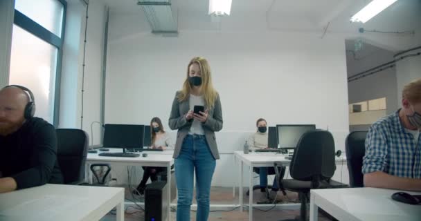 Empresária Usando Máscara Segurando Smartphone Enquanto Caminha Escritório — Vídeo de Stock