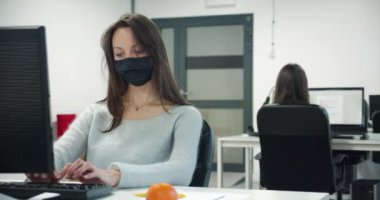Ofiste çalışırken maske takan genç bayan. 