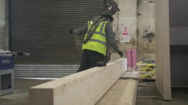 WS İnşaat işçisi tahta kirişi vinçten ayırıyor, Mansfield, İngiltere, İngiltere