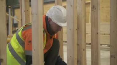 MS SLO MO İnşaat İşçisi Ahşap çerçeve üzerinde çalışıyor, İngiltere, İngiltere