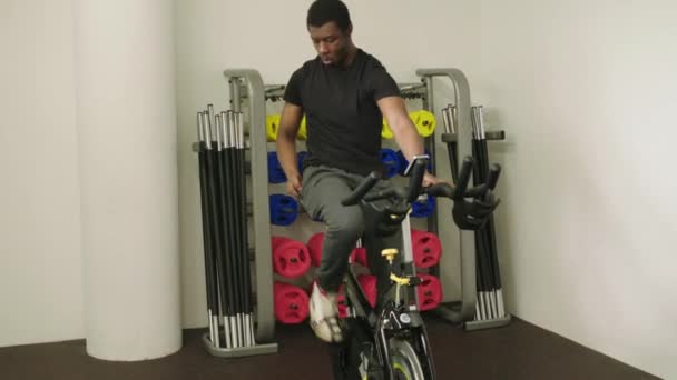 Man Entrenamiento Bicicleta Estática Gimnasio Uso Teléfono Nottingham Inglaterra Reino — Vídeos de Stock