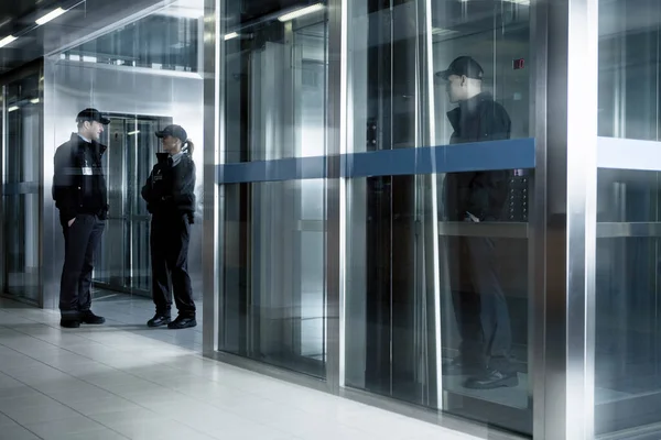 Asansörün Yanındaki Koridorda Duran Güvenlik Görevlileri Stok Fotoğraf