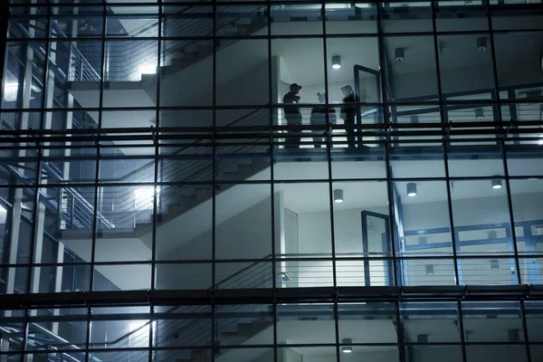 Geceleri Ofis Pencerelerinden Güvenlik Görevlilerinin Siluetleri Görülüyor - Stok İmaj