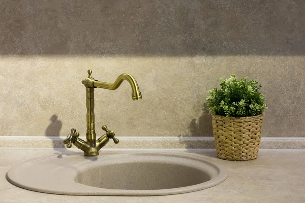 round porcelain tile kitchen sink on the kitchen countertop and retro brass faucet