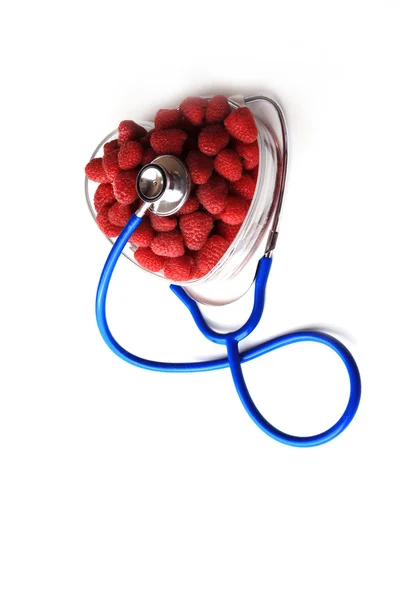 Estetoscopio azul y frambuesas rojas en forma de corazón — Foto de Stock