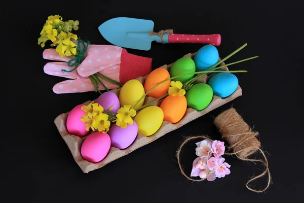 Uova di Pasqua colorate con pennarelli colorati, corda e fiori gialli primaverili — Foto Stock