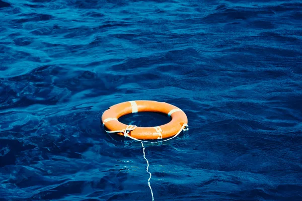 Une bouée de sauvetage orange flottant au milieu de l'océan Photos De Stock Libres De Droits