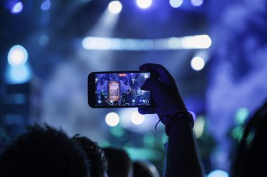 Müzik fanı konser cep telefonu. DJ partisinde akıllı telefonlardan kaydedilen heyecan verici yıldırım.