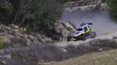 LARNACA, CYPRUS - 14 Aralık 2025: Kıbrıs Rum Kesimi, Kornos bölgesinde toplandı. Bir Can-AM Maverick X3 arabasının tozlu bir yolda yarışının yavaş çekim görüntüleri..