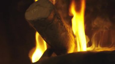 Şöminede yanan odun. 4K yavaş çekim videosu. Arka plan videoları. Alevler yavaşça yanan odunları dışarı çıkarıyor..