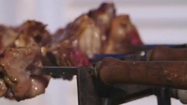 4K gerçek zamanlı Kıbrıs Rum geleneksel souvla pişirme görüntüsü. Paskalya Günü ızgarada tavuk ve lamba pişirirken..