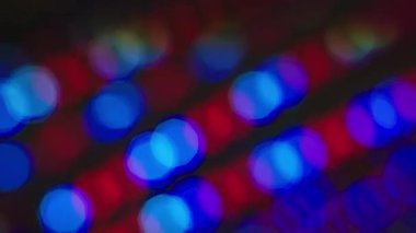 Çok renkli parıltılı ışıklar, odaklanmış ışık yansımaları. Döngülü bokeh arka plan ağır çekim 4K. Odak damlaları şablon olarak canlandırıldı.