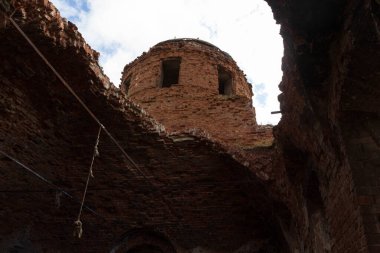 Terk edilmiş bir kırmızı tuğla kilise binası.