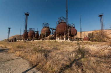 abandoned factory with rusty cisterns