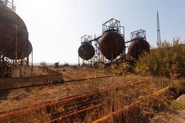 abandoned factory with rusty cisterns