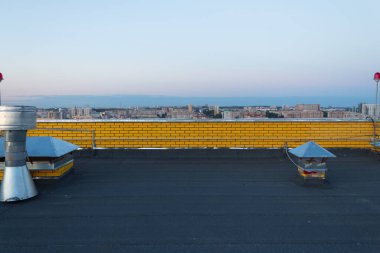 Çok katlı yeni bir binanın çatısında.