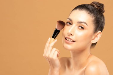 Güzel Asyalı kadın makyaj fırçasıyla makyaj fırçası ve neşe dolu
