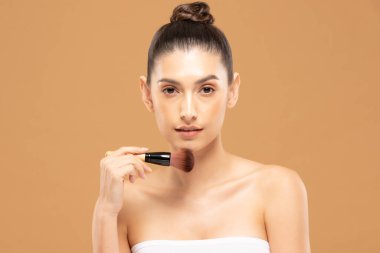 Güzel Asyalı kadın makyaj fırçasıyla makyaj fırçası ve neşe dolu