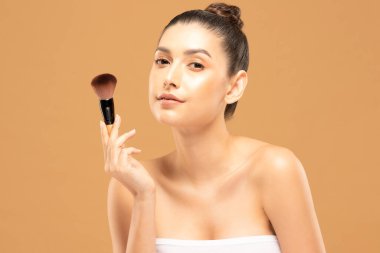 Güzel Asyalı kadın makyaj fırçasıyla makyaj fırçası ve neşe dolu