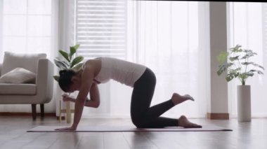 Asyalı kadın evde pilates yoga yapıyor..