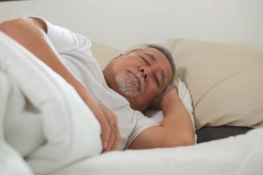 Asyalı yaşlı adam uyuyor ve tatlı rüyalar görüyor..