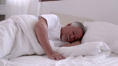 Asyalı yaşlı adam uyuyor ve tatlı rüyalar görüyor..