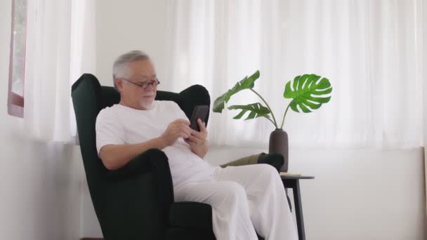 Asian Elderly Man Play Smartphone Room — Stock Video