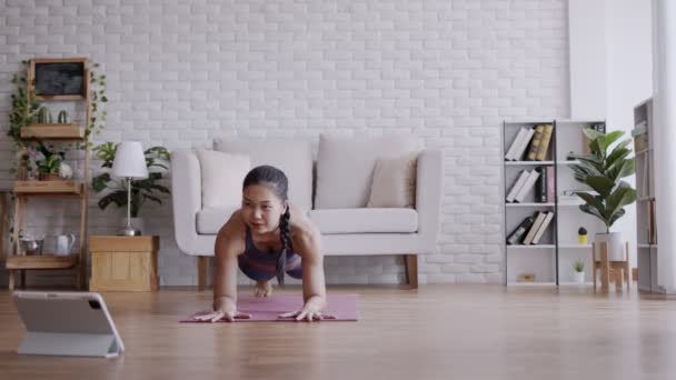 亚洲女人看起来像笔记本电脑 在家练习瑜伽板 — 图库视频影像