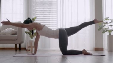 Pilates egzersizinden sonra su içen Asyalı kadın yoga yapıyor..