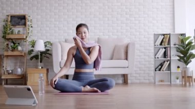 Pilates egzersizinden sonra su içen Asyalı kadın yoga yapıyor..