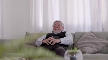 Asyalı bir ihtiyar, dinlendirici bir günde kanepeye uzanır..