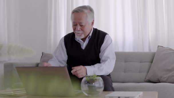 Літній Азіатський Чоловік Працює Помічає Роботу Своєму Ноутбуку Вдома — стокове відео
