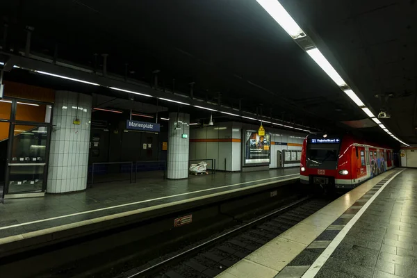 ミュンヘンの中心部にあるマリエンプラッツのほとんど空の駅で 春のコロナウイルス発生時に赤いS Bahn列車が到着します — ストック写真