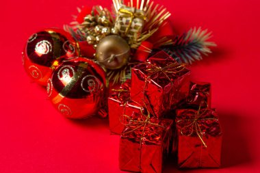Kırmızı arka planda Noel süslemeleri. Noel süsleri. Tatil süslemeleri. Kırmızı hediye kutuları. Kırmızı Noel topları. Noel konsepti
