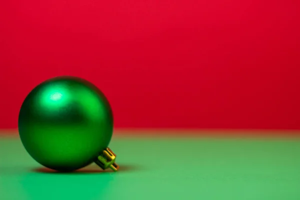 Green Christmas ball on a red background. Christmas decorations on a red background. Holiday decorations. Christmas concept.