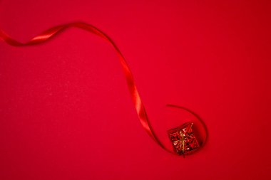 Kırmızı arka planda kırmızı kurdeleli kırmızı hediye. Tatil süslemeleri. Noel konsepti. 